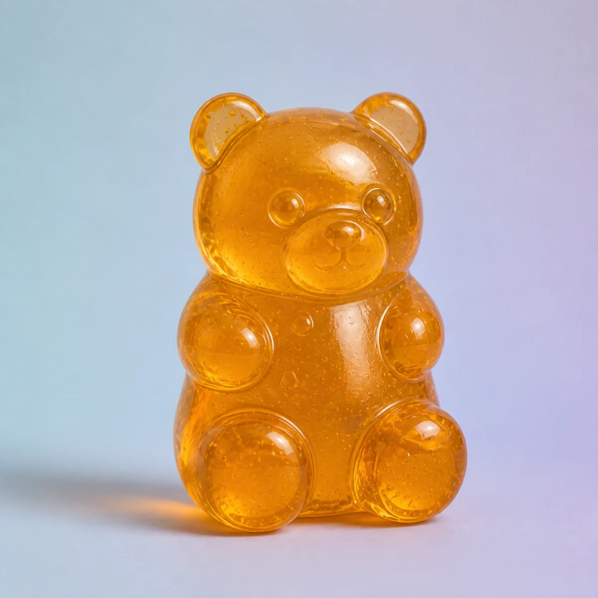 Sweet Bear Jelly Squish, Amber shown on a soft pastel studio background