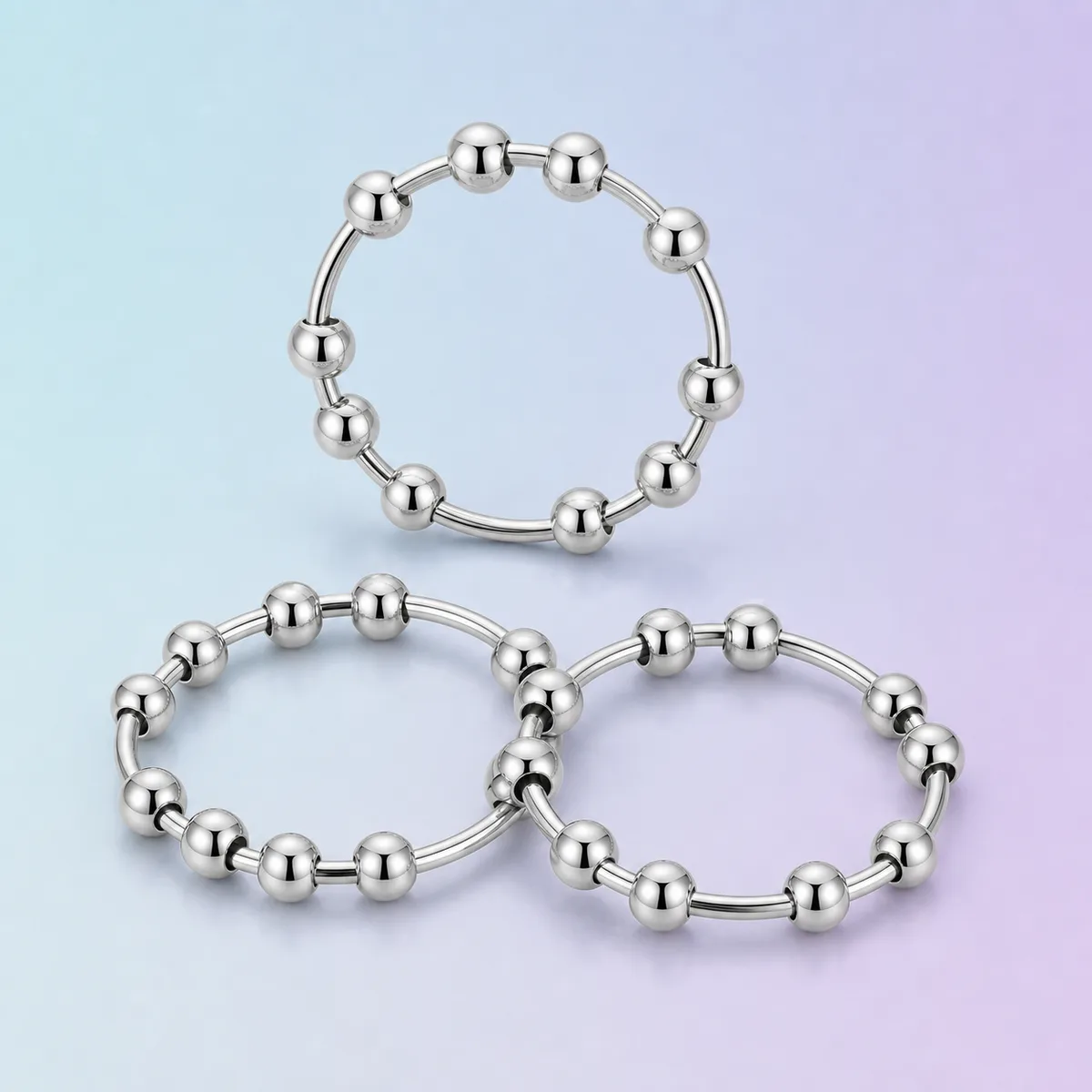 Quiet Spinner Sensory Ring Set (3-Pack), Silver shown on a soft pastel studio background